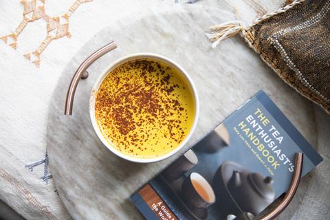 bowl of yellow turmeric tea with cinnamon sprinkled on top