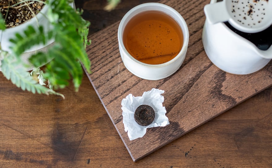 Shou Puerh Tou Cha tea on a wooden board in a white mug