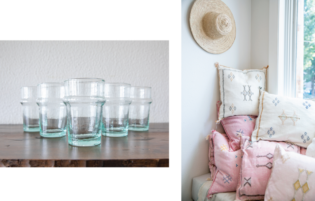 a display of clear beldi tea glasses and turkish pillows